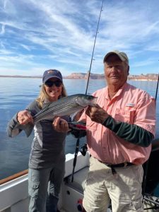 Spring Fishing starts on Lake Powell - Captain Bill McBurney and Guest holding a nice sized striper.